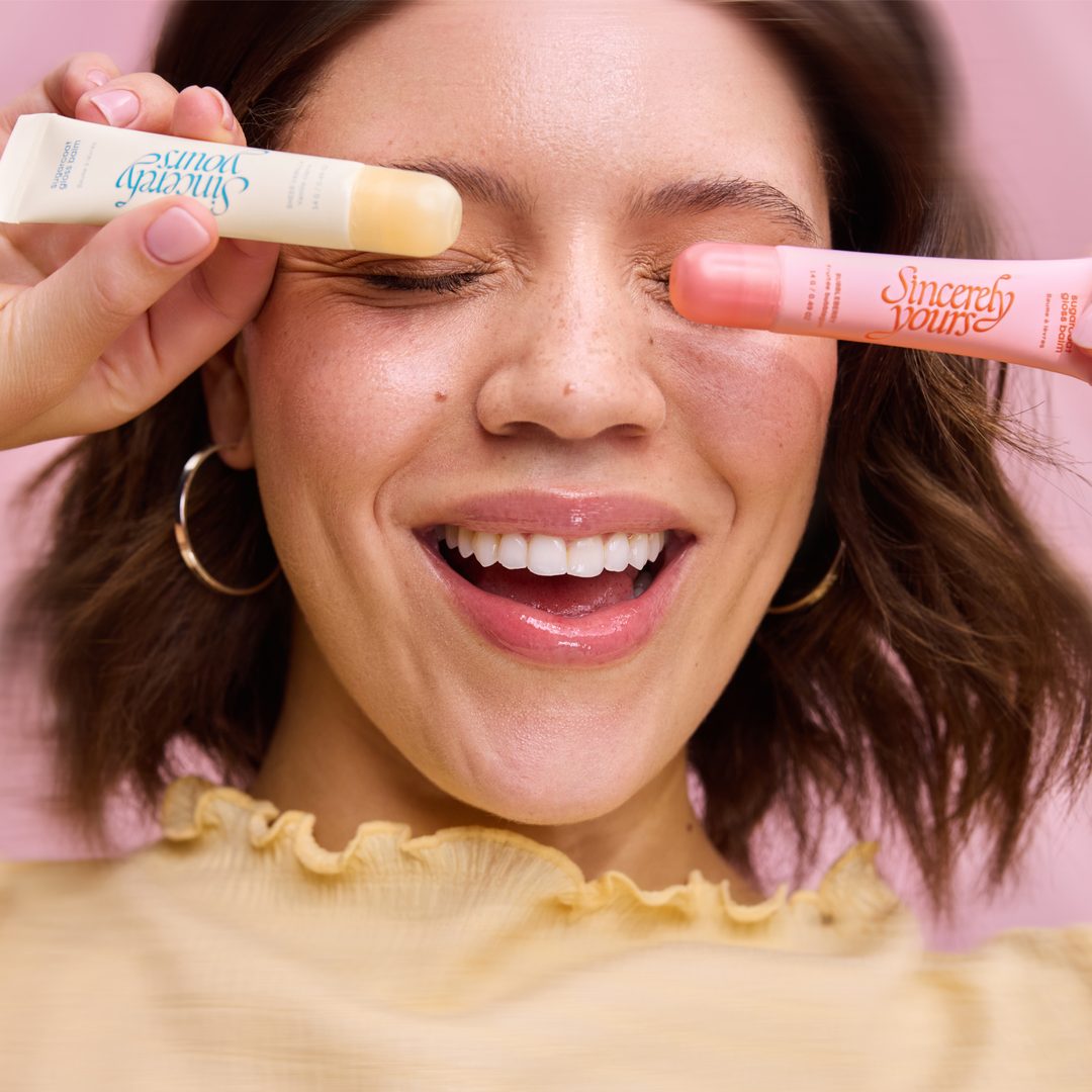 Model holding both sugarcoat gloss balms