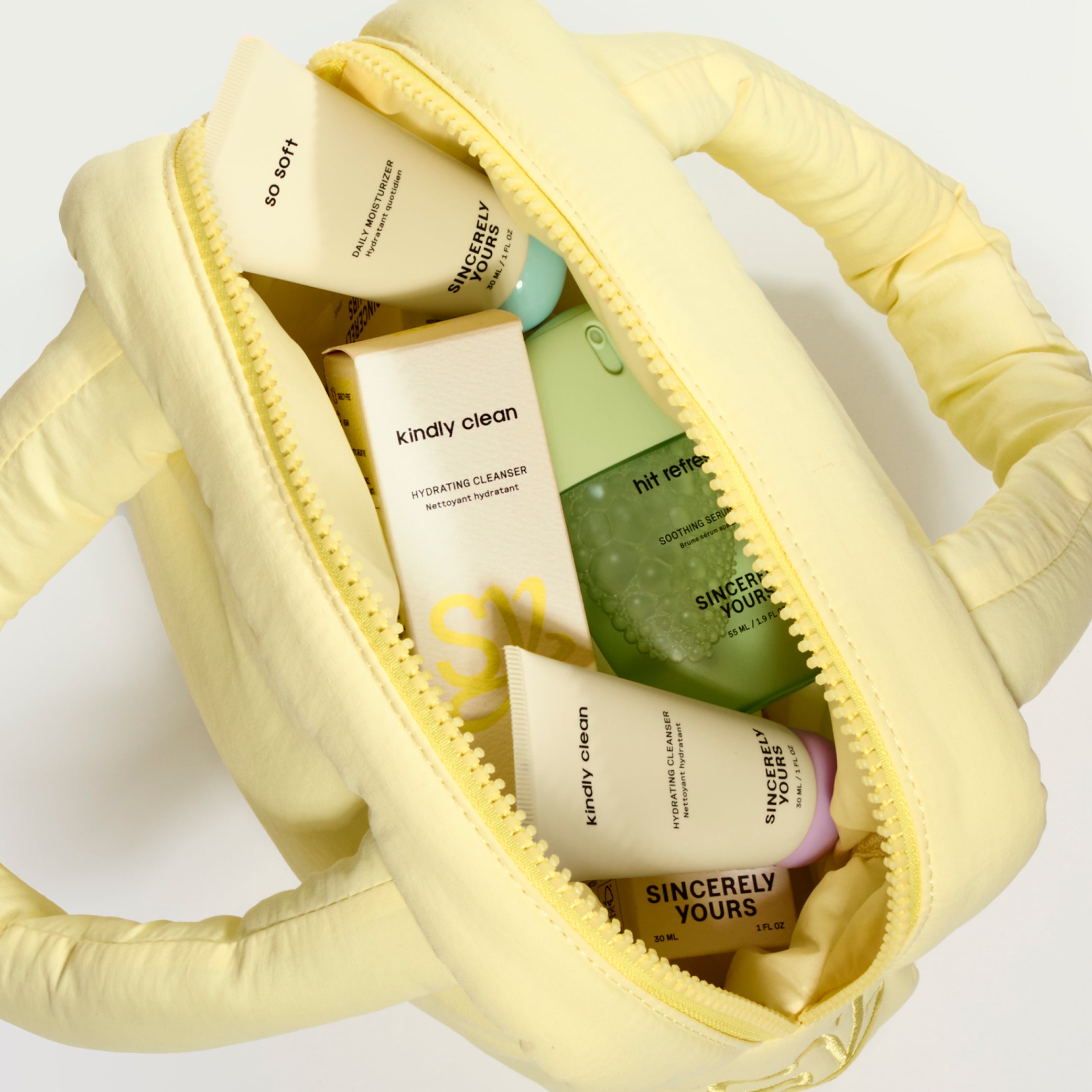 Yellow cosmetic bag with skincare products on a white background