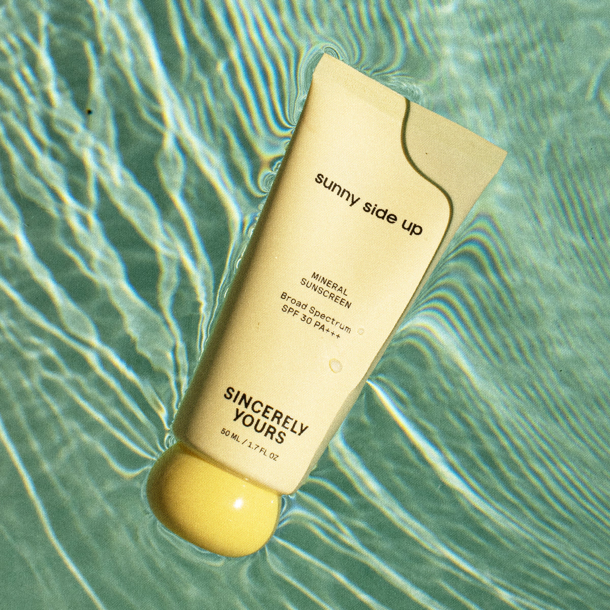 50 ml | Sunscreen bottle labeled 'sunny side up' on a water surface